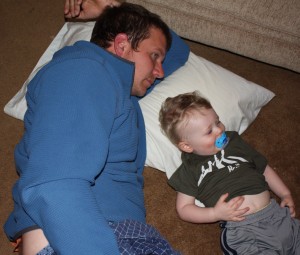 daddy relaxes with toddler on the floor